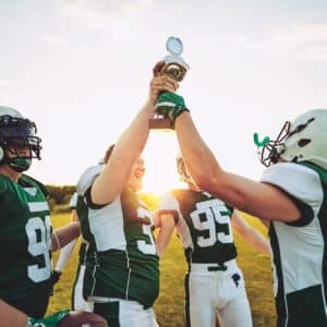 Football players raising a trophy together after winning the championship